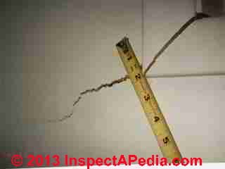 Sinking house drywall cracking, also bad tape (C) InspectApedia.com